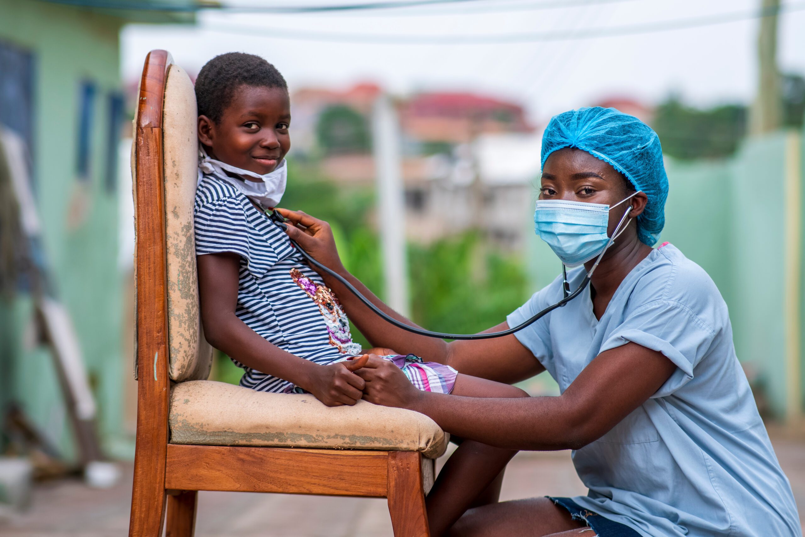 African Health Worker Wearing a Surgical Face Mask and Child